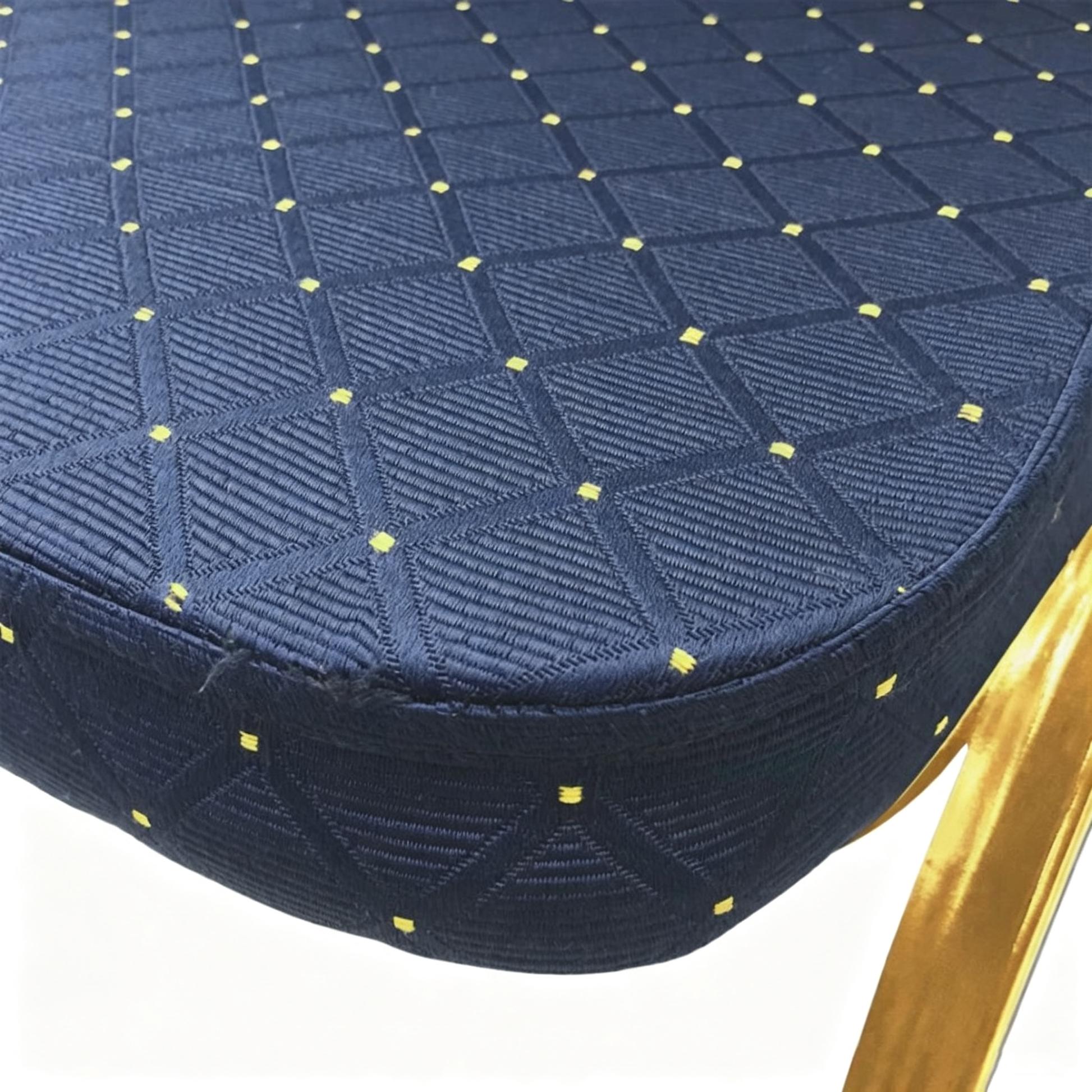 Close-up of royal blue patterned upholstered seat with gold dot detail and gold frame